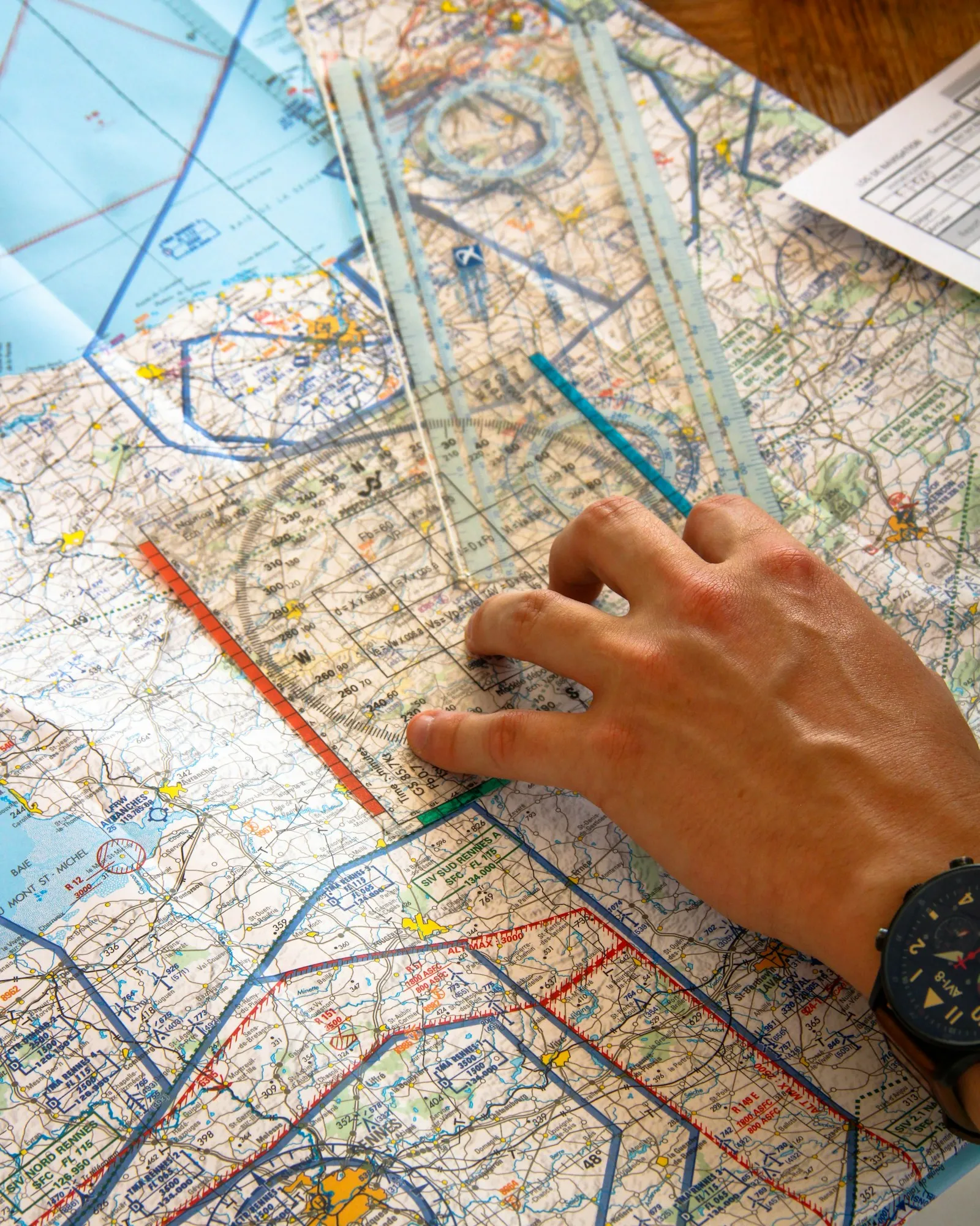 Flight planning paperwork: hand plotting a route on an aeronautical chart with a navigation ruler