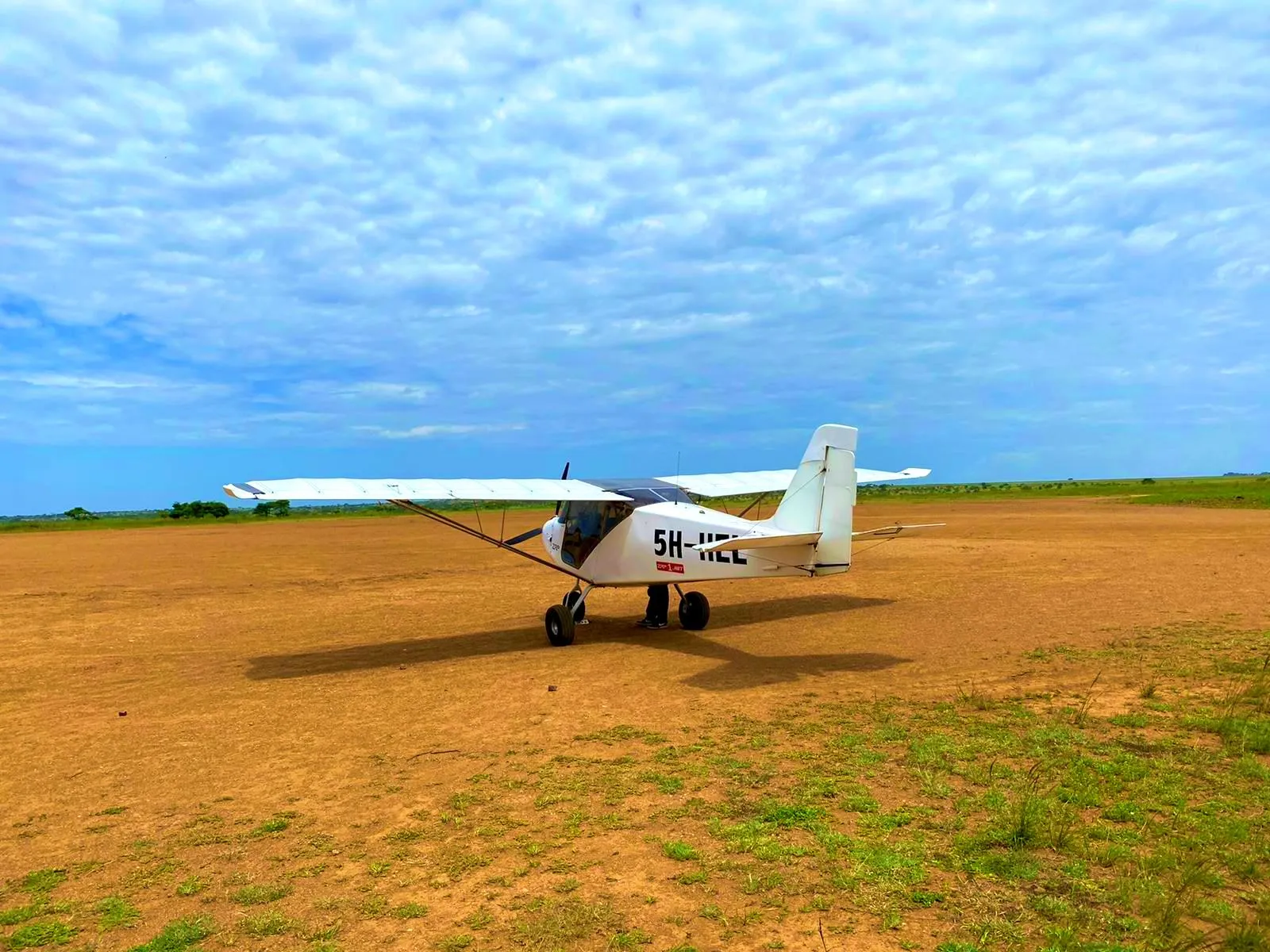ZRP light sport aircraft 5H-HEL parked on a bush airstrip in the Tanzanian savannah
