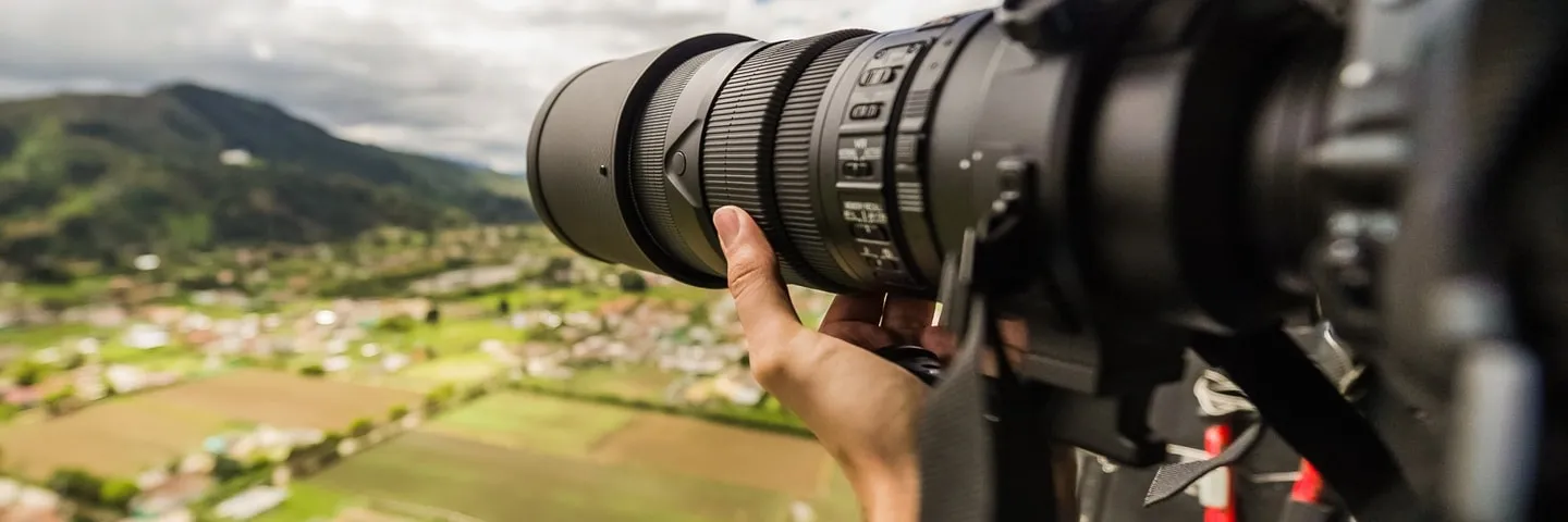 Telephoto camera pointed at a landscape from the air